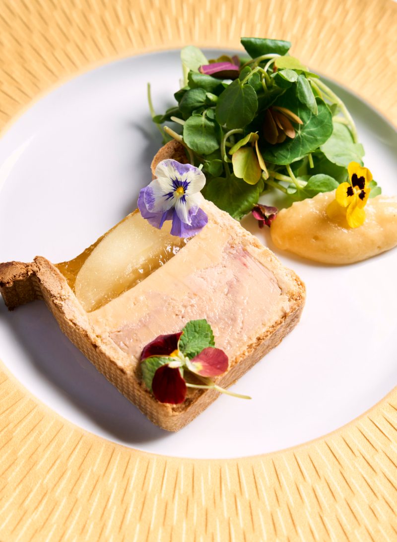 Foie gras terrine en croûte with poached pear, watercress and edible flowers