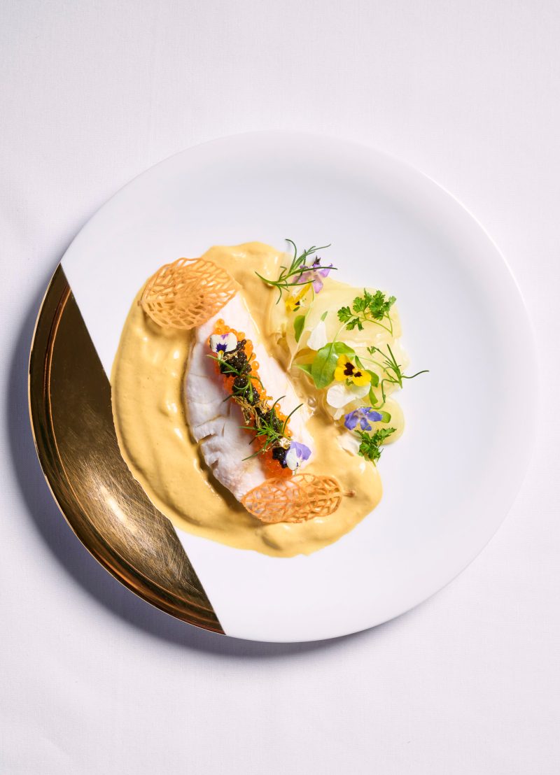 Poached fish in a saffron cream sauce with caviar, trout roe and gold leaf